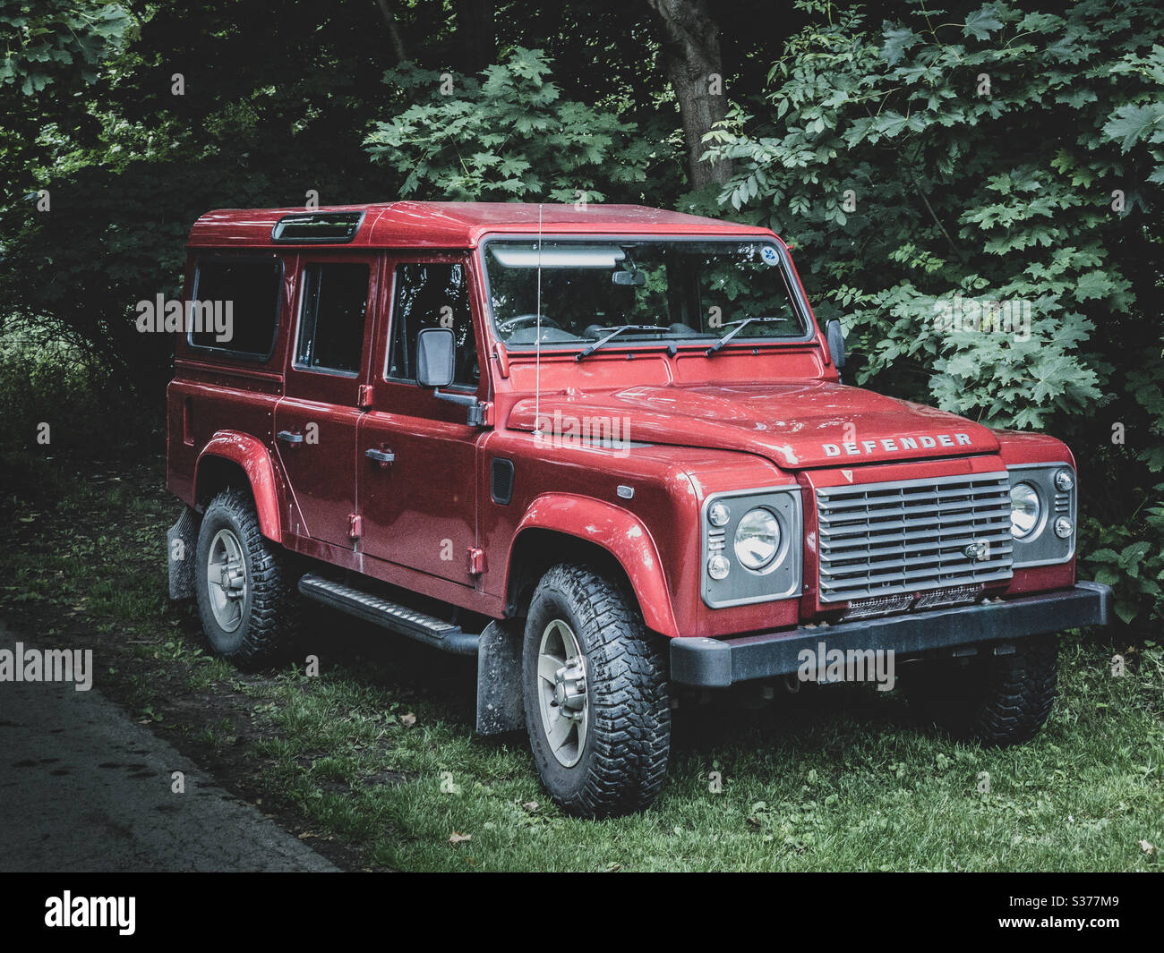 Red Land Rover Defender 110 four wheel drive car parked on grass Stock Photo Alamy