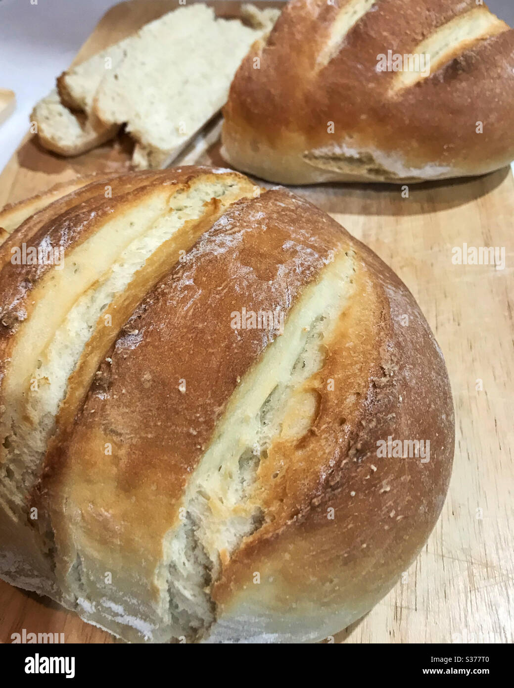 Homemade bread loaves on a wooden bread board - Smartphone Captured Stock Image