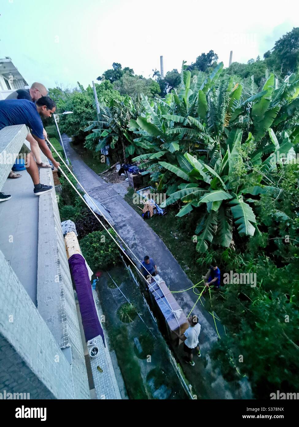 Hoisting furniture up the building in Hong Kong. - Smartphone Captured Stock Image