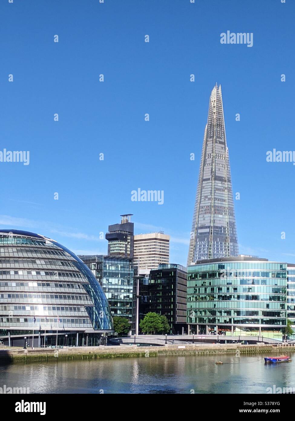 London Shard and Mayor office building on clear blue sky day Stock Photo