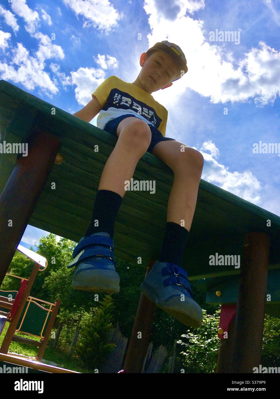 Boy child kid sitting on top of wooden toy train at playground - Smartphone Captured Stock Image