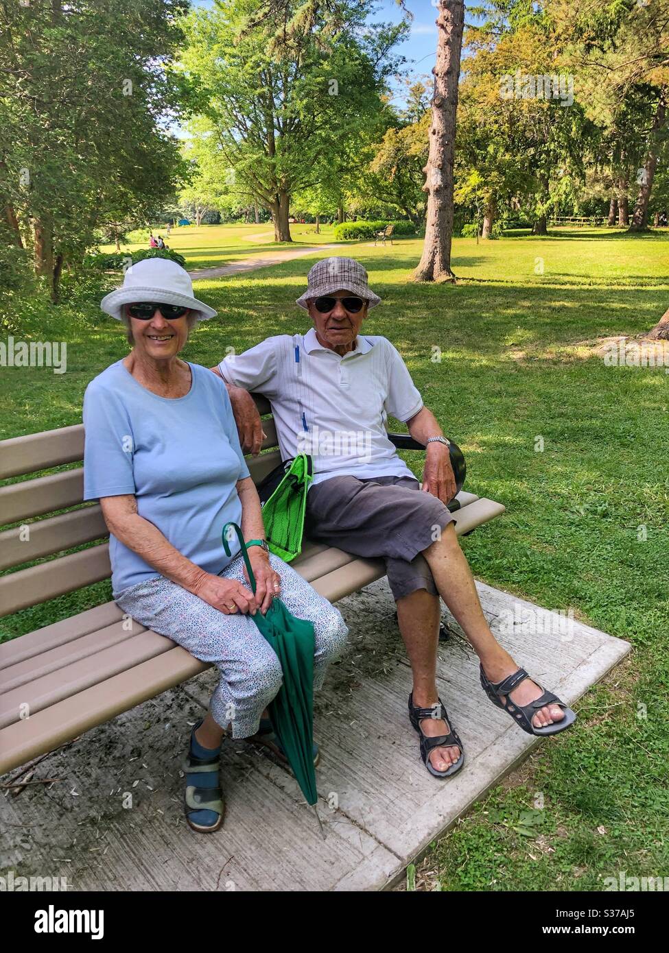 An elderly couple sitting on a park bench. - Smartphone Captured Stock Image