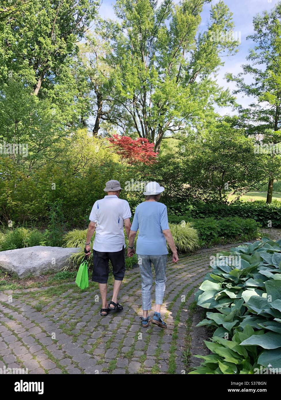 An elderly couple walking hand in hand. - Smartphone Captured Stock Image