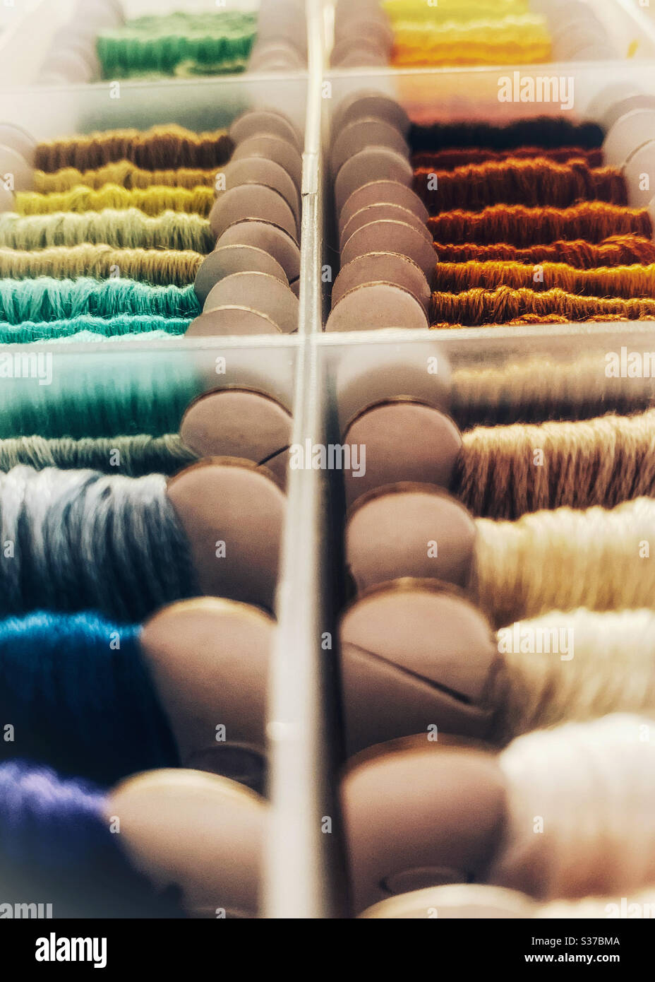 Closeup of embroidery threads on cardboard bobbins organised in a box - Smartphone Captured Stock Image