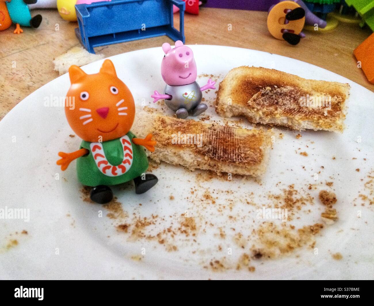Peppa Pig and Candy Cat eating breakfast. Stock Photo