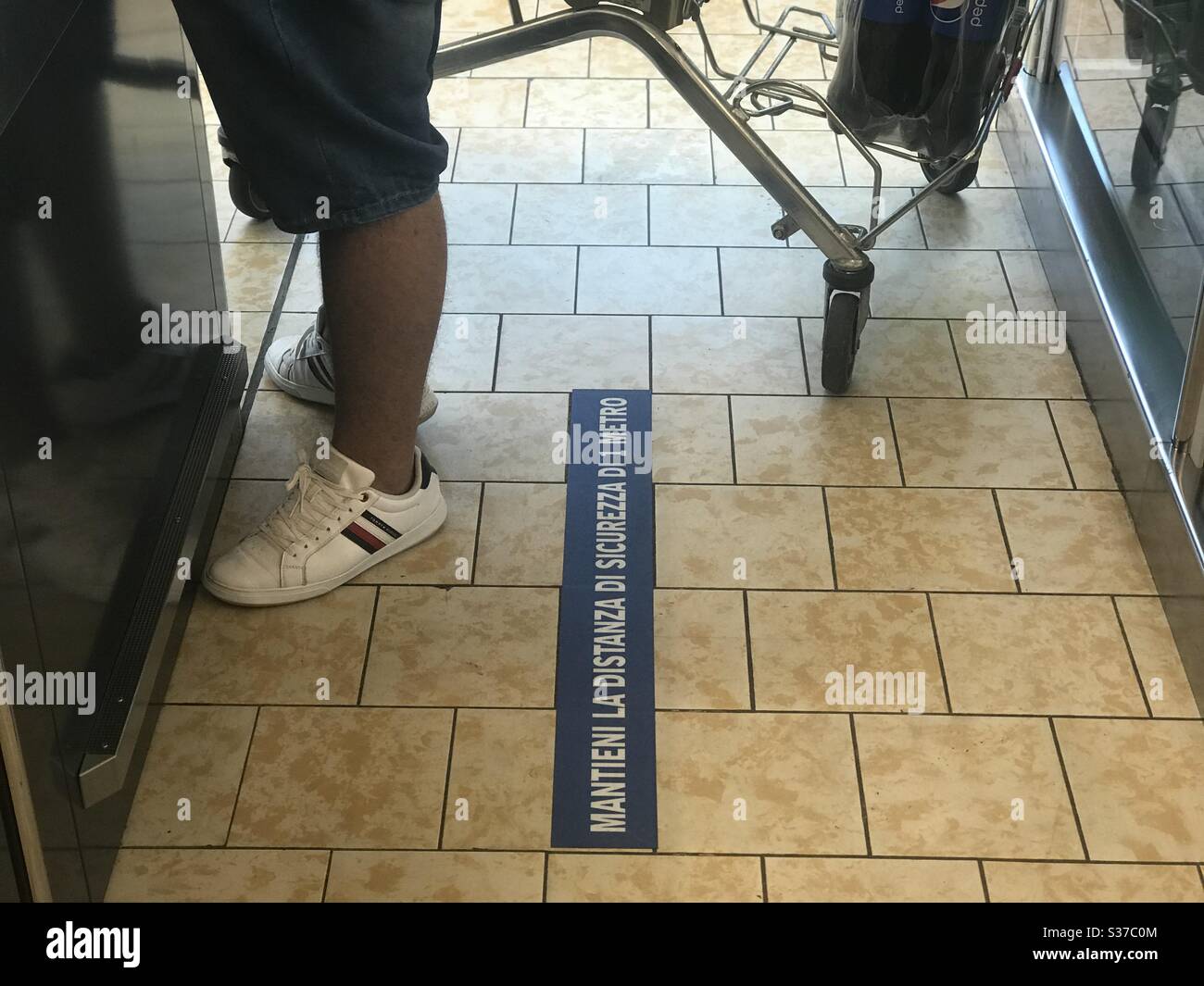 Customer waits in the grocery store to pay and load cart with social distancing - Smartphone Captured Stock Image