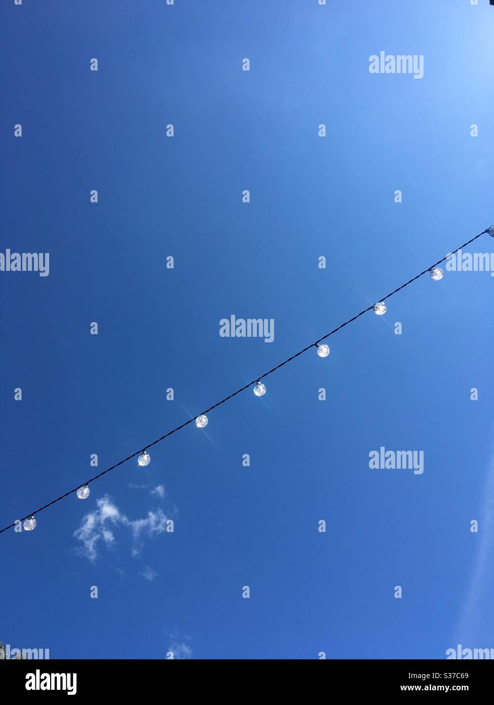 Blue sky with string of solar lights - Smartphone Captured Stock Image