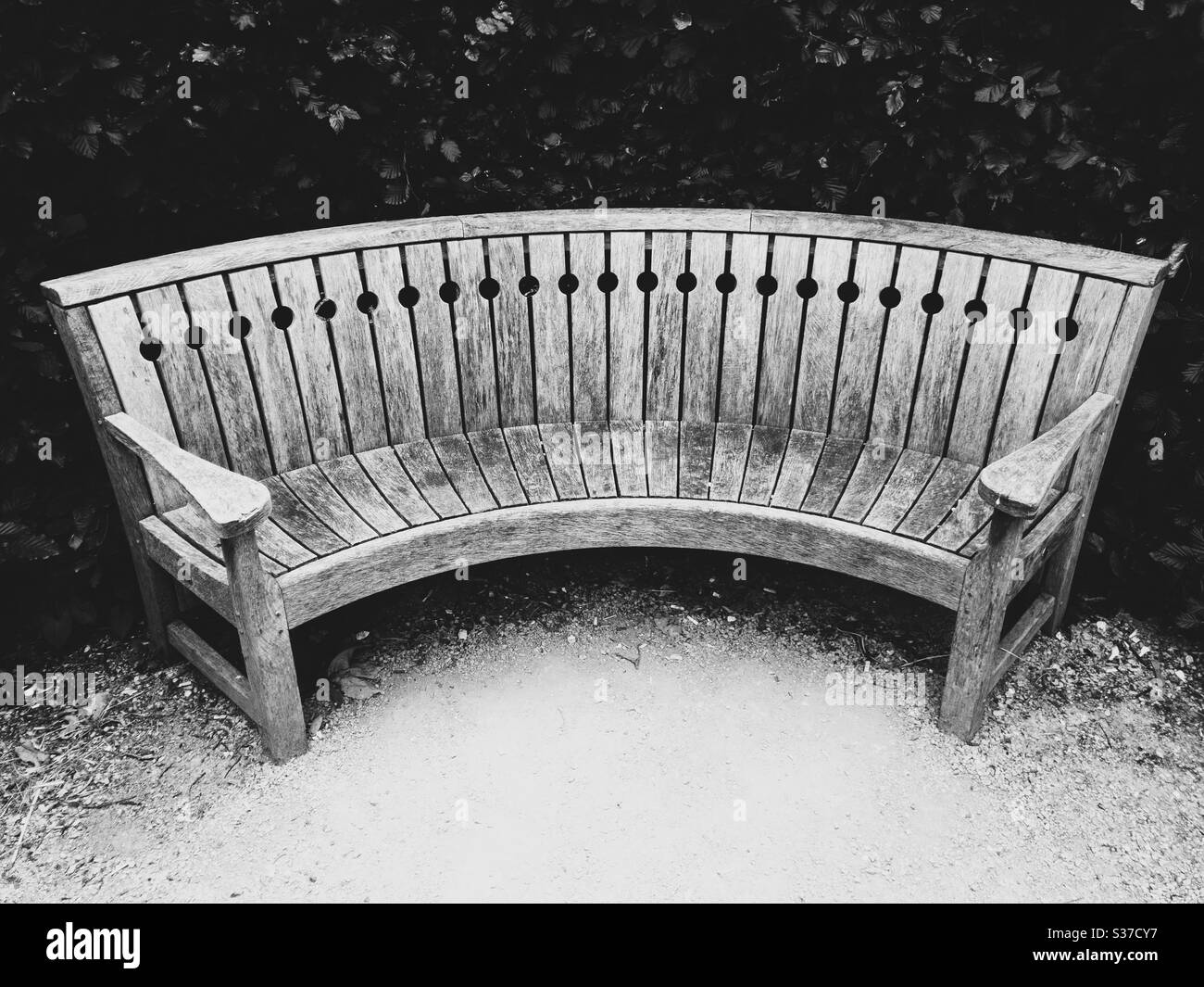 Seat. A curved wooden garden bench. Stock Photo