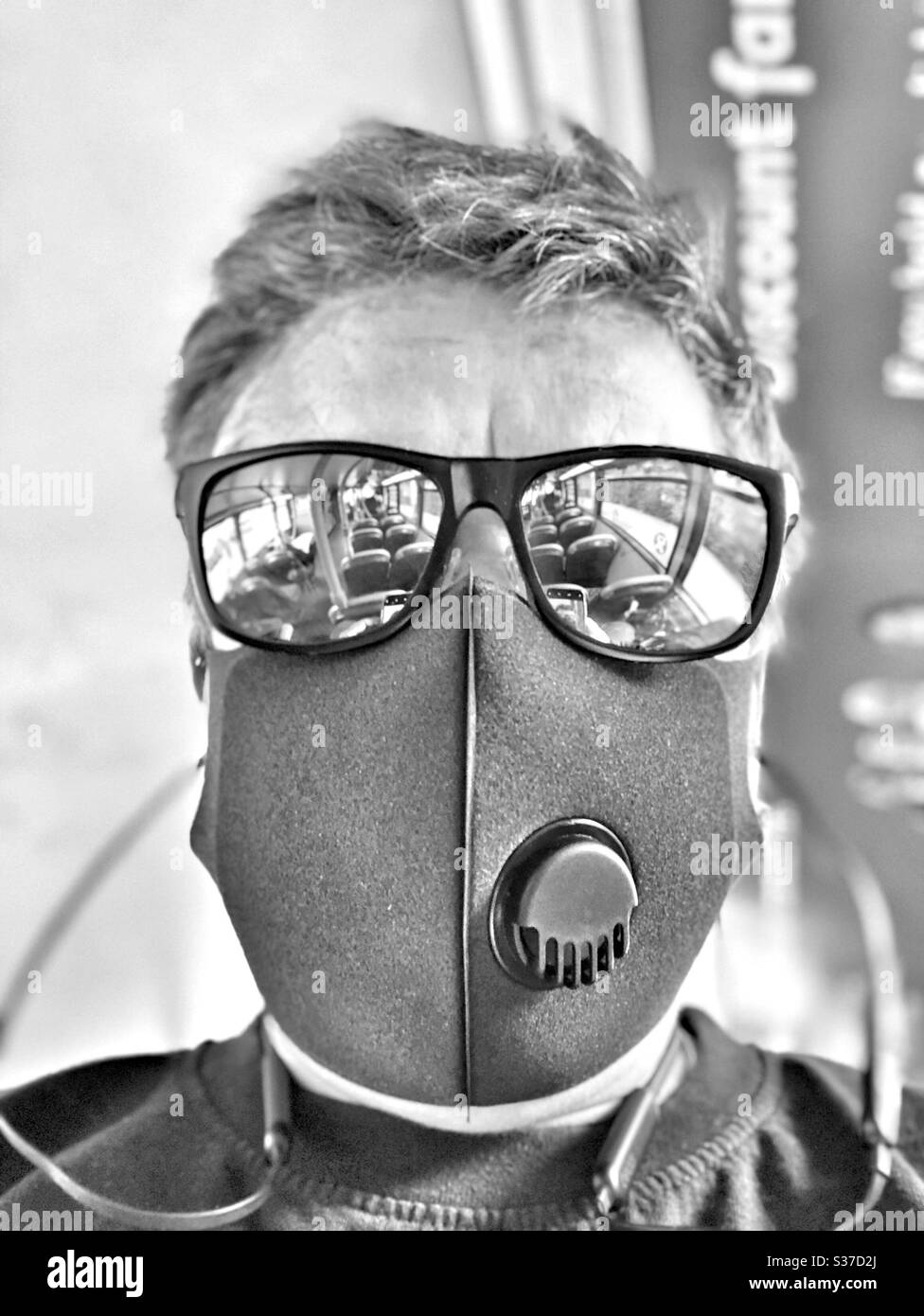 Black and white photo of woman wearing a face mask whilst travelling on a bus - Smartphone Captured Stock Image