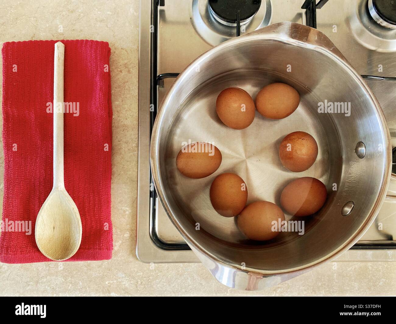 Closeup view of free range organic farm eggs in a pan of boiling water. Preparing hard boiled eggs on the stovetop. Gently simmering over gas stove. - Smartphone Captured Stock Image