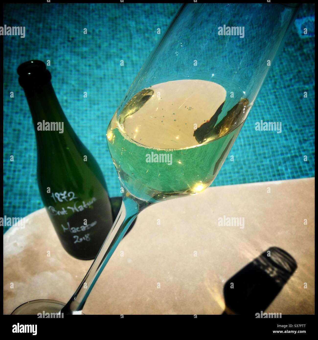 Homemade Macabeo sparkling wine by the pool, Catalonia, Spain. - Smartphone Captured Stock Image