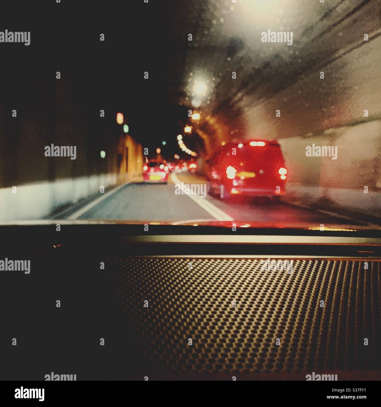 Cars driving through the Tyne Tunnel in North East England. Blurry red brake lights are seen through the windshield. Transport infrastructure. - Smartphone Captured Stock Image
