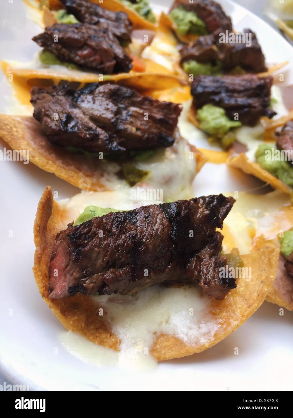 Close up of a restaurant entrée of steak nachos served at a Mexican restaurant in New York City, USA - Smartphone Captured Stock Image Close up of a restaurant entrée of steak nachos served at a Mexican restaurant in New York City, USA - Smartphone Captured Stock Image