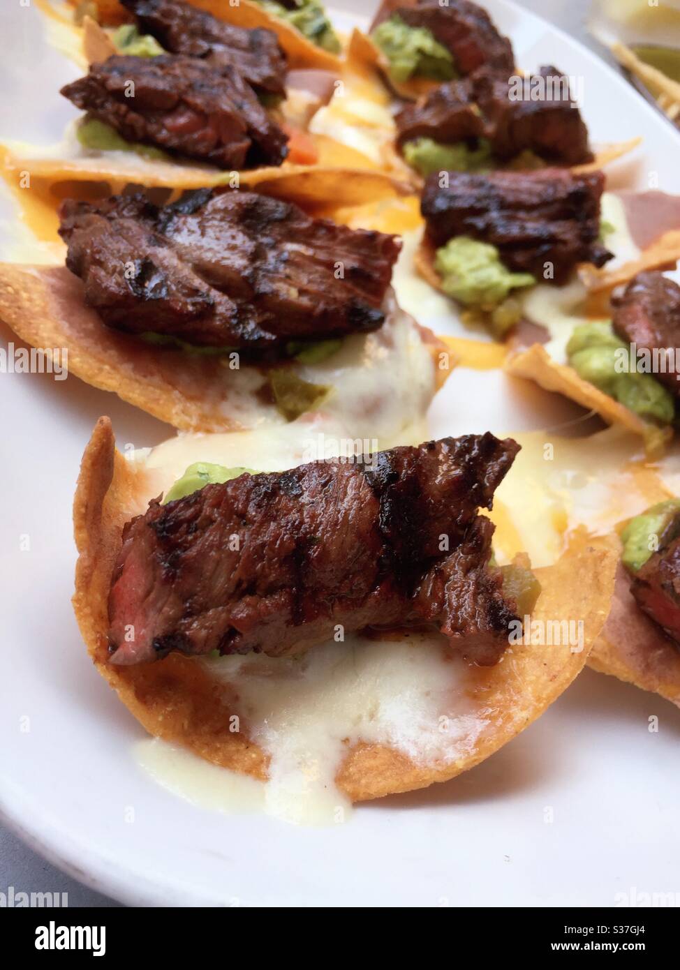 Still life of a platter of steak nachos served in a Mexican restaurant in New York City, USA - Smartphone Captured Stock Image Still life of a platter of steak nachos served in a Mexican restaurant in New York City, USA - Smartphone Captured Stock Image