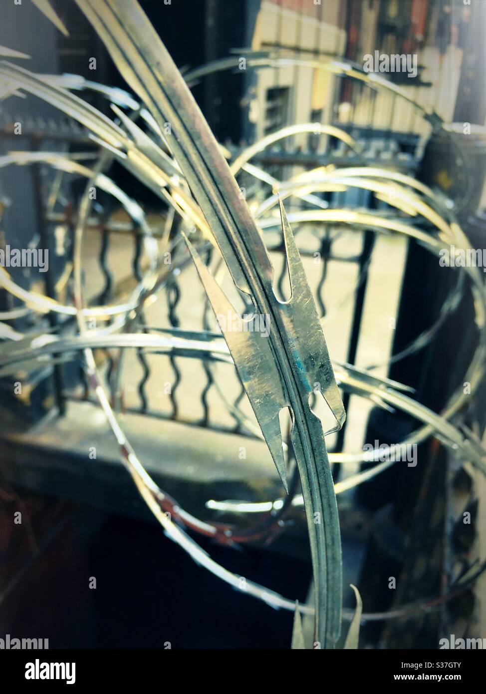Close up of the blades on coils of concertina wire placed in front of a building in New York City, NYC, USA - Smartphone Captured Stock Image