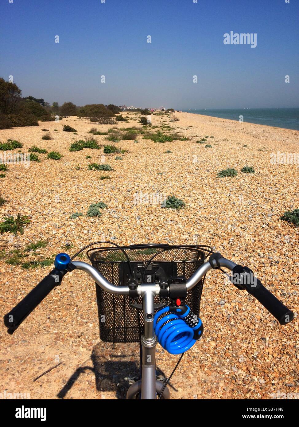 The handlebars of a bike facing up the beach at Walmer, Deal,Kent UK - Smartphone Captured Stock Image