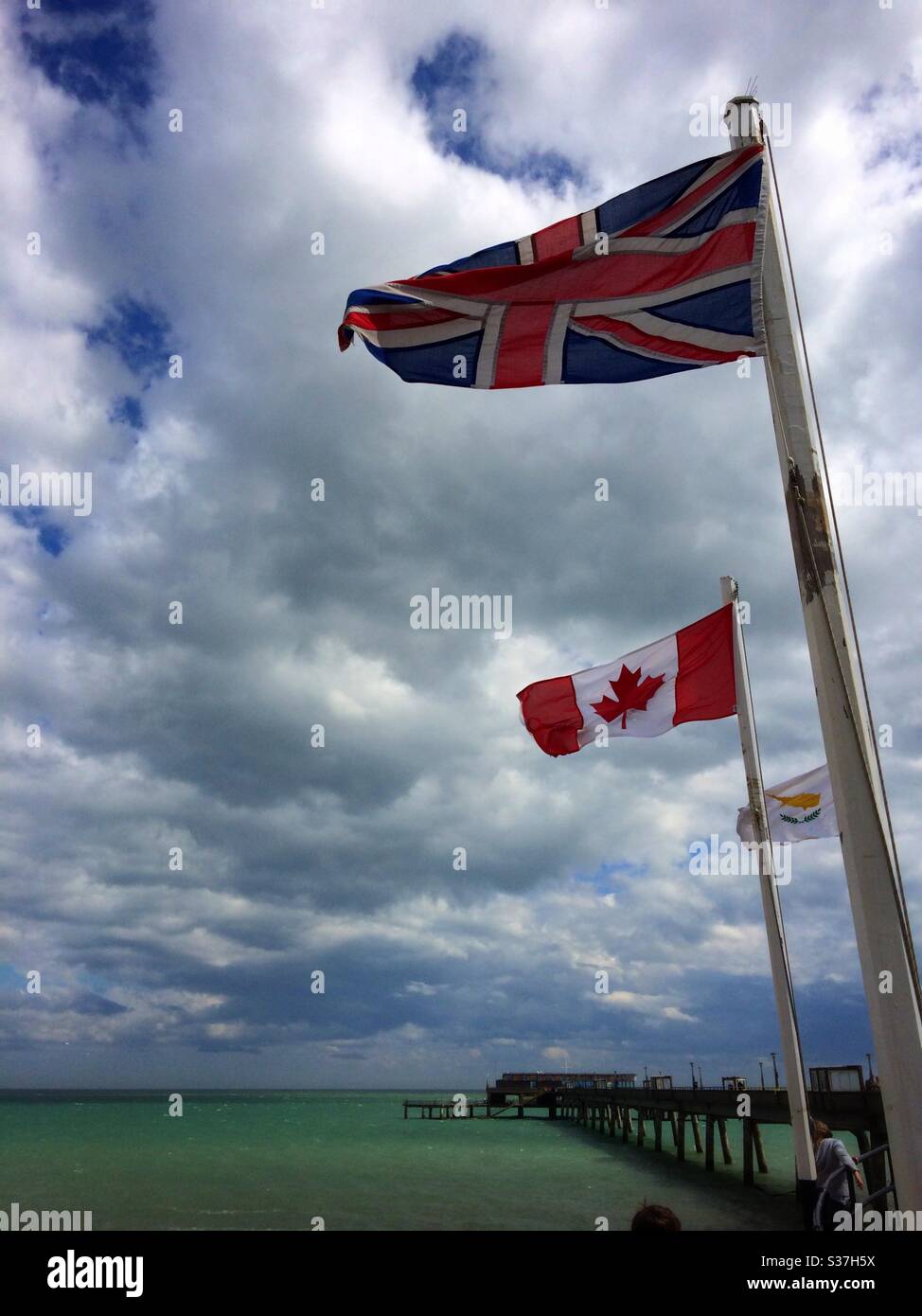 The Union Jack & Canadian flags flying at the entrance to Deal pier Kent UK - Smartphone Captured Stock Image