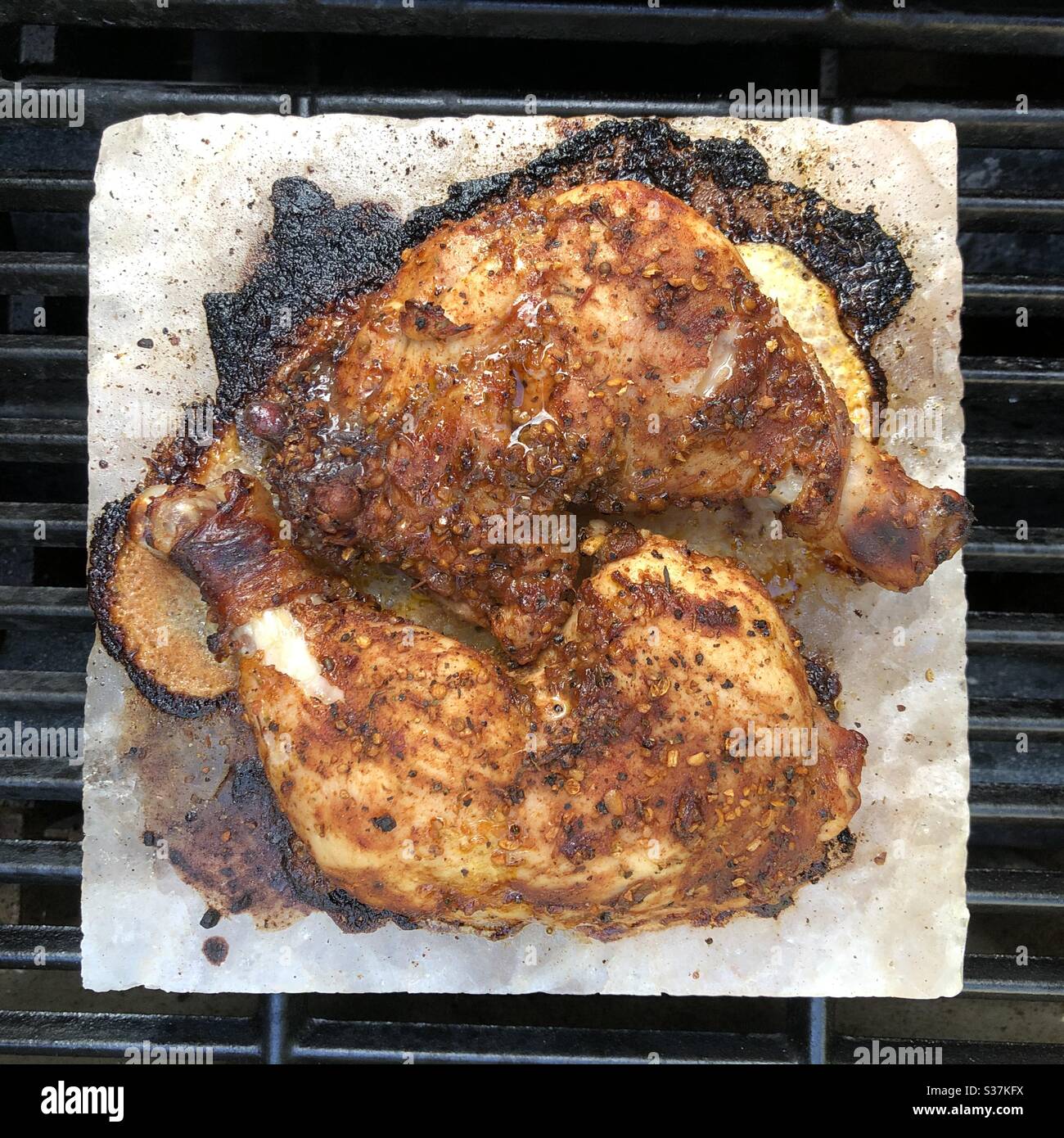 Chicken legs being barbecued on the Himalayan pink salt block. - Smartphone Captured Stock Image