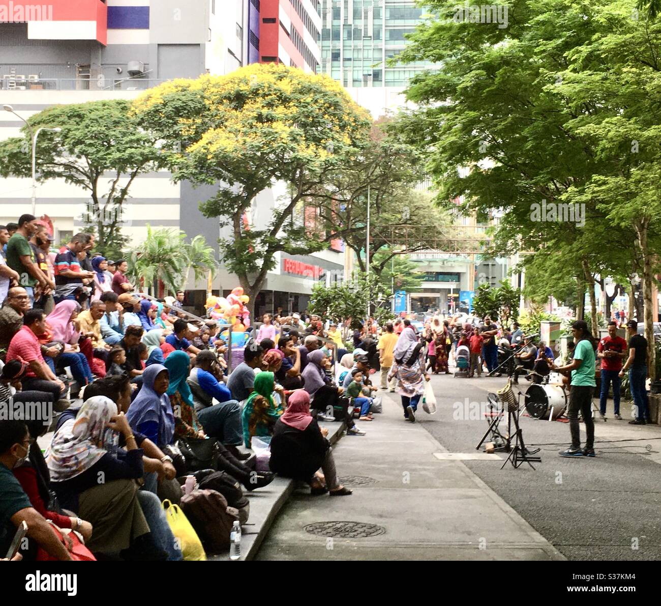 Crowd watching musician perform concert on street in Kuala Lumpur Malaysia Stock Photo