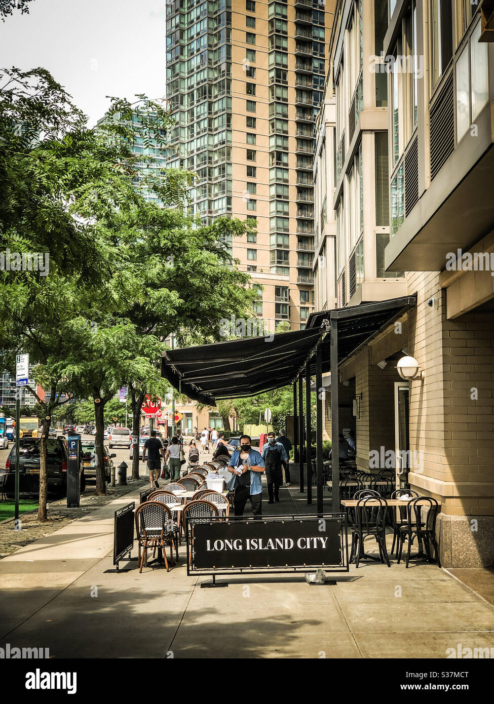New York City first weekend on phase two after the COVID-19 pause. Bars and restaurants in Long Island City, Queens, taking over sidewalk in order to keep social distance recommendations Stock Photo