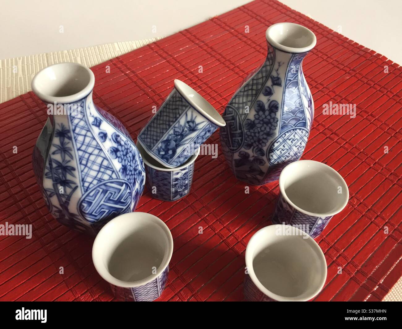 Sake set still life on a red bamboo placemat - Smartphone Captured Stock Image
