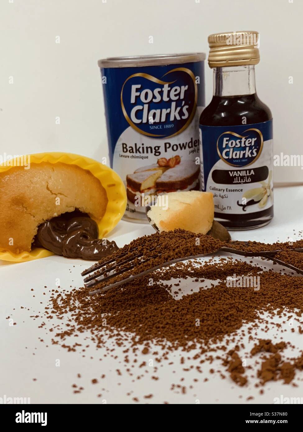 Baked Cupcake with baking powder and Foster Clark's Vanilla with chocolate  paste and a sprinkle of cocoa powder and a piece of cake on a spoon Stock  Photo - Alamy