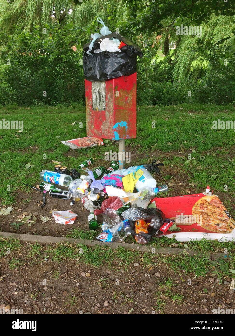 Full overflowing red rubbish bin. Why add to it, take your rubbish home. UK - Smartphone Captured Stock Image