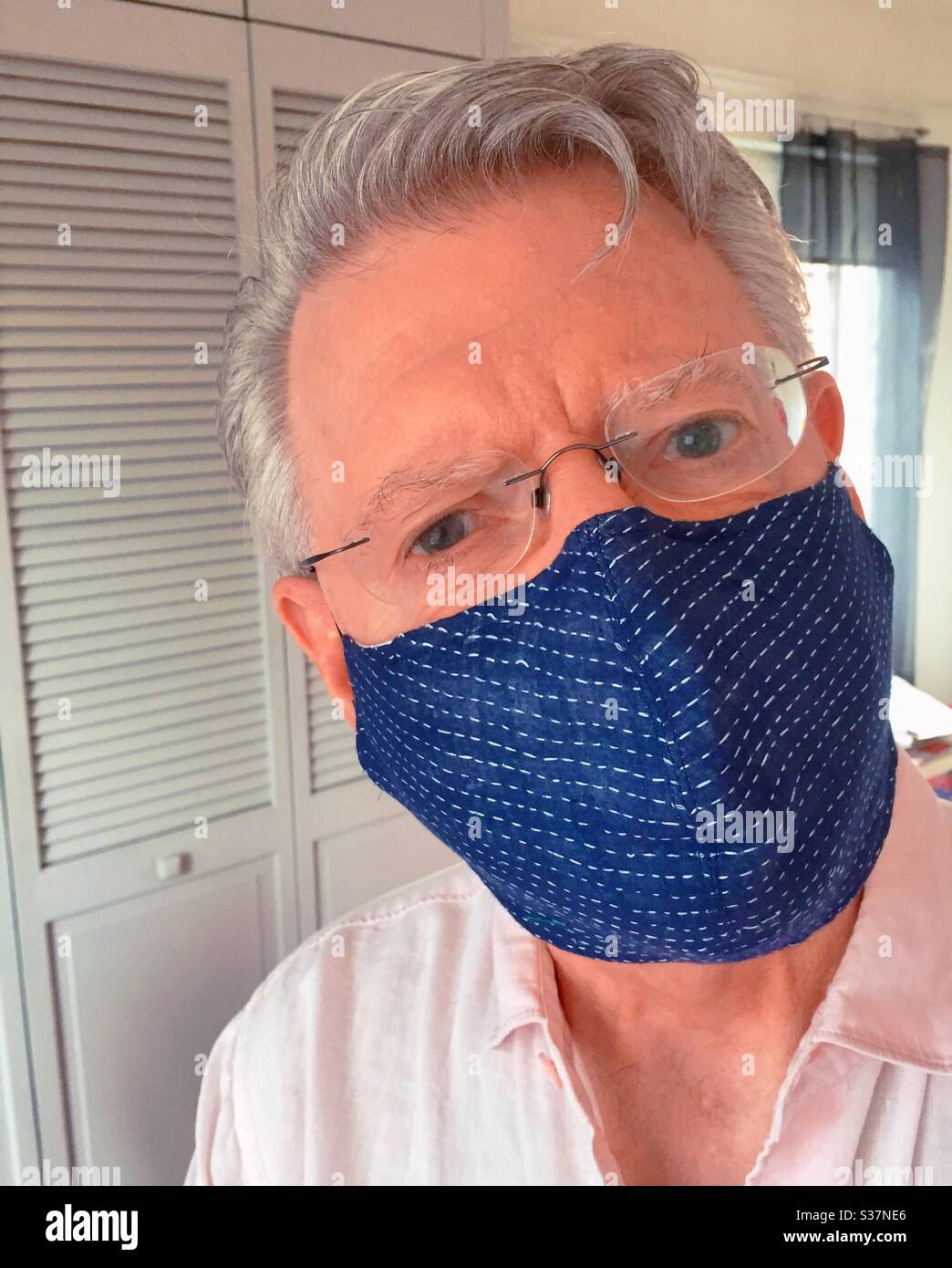 Senior man wearing a face mask from a Japanese designer during the COVID-19 pandemic, 2020, NYC, USA - Smartphone Captured Stock Image