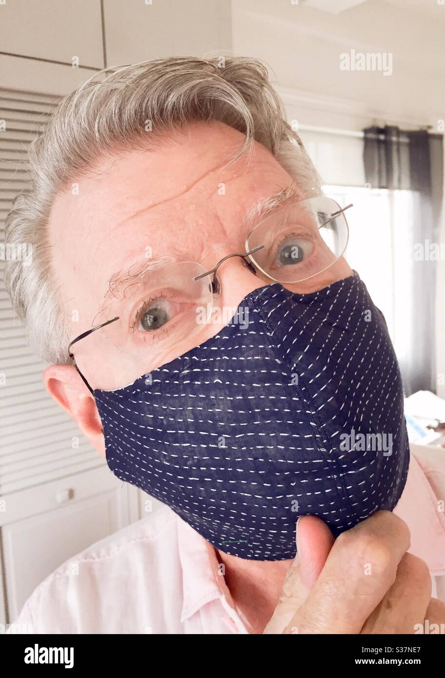 Senior man wearing a face mask from a Japanese designer during the COVID-19 pandemic, 2020, NYC, USA - Smartphone Captured Stock Image