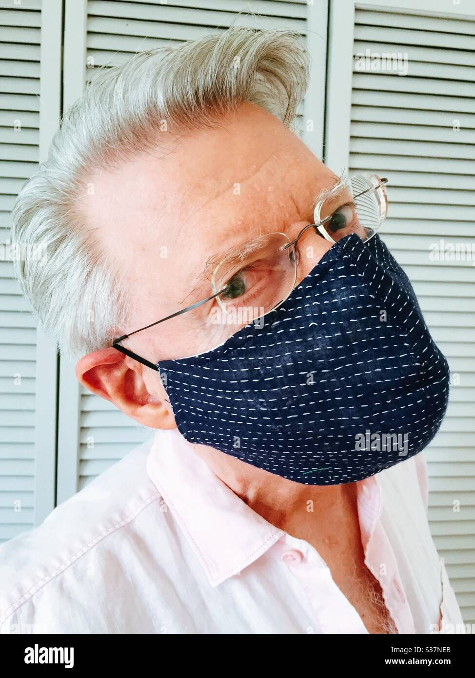 Senior man wearing a face mask from a Japanese designer during the COVID-19 pandemic, 2020, NYC, USA - Smartphone Captured Stock Image