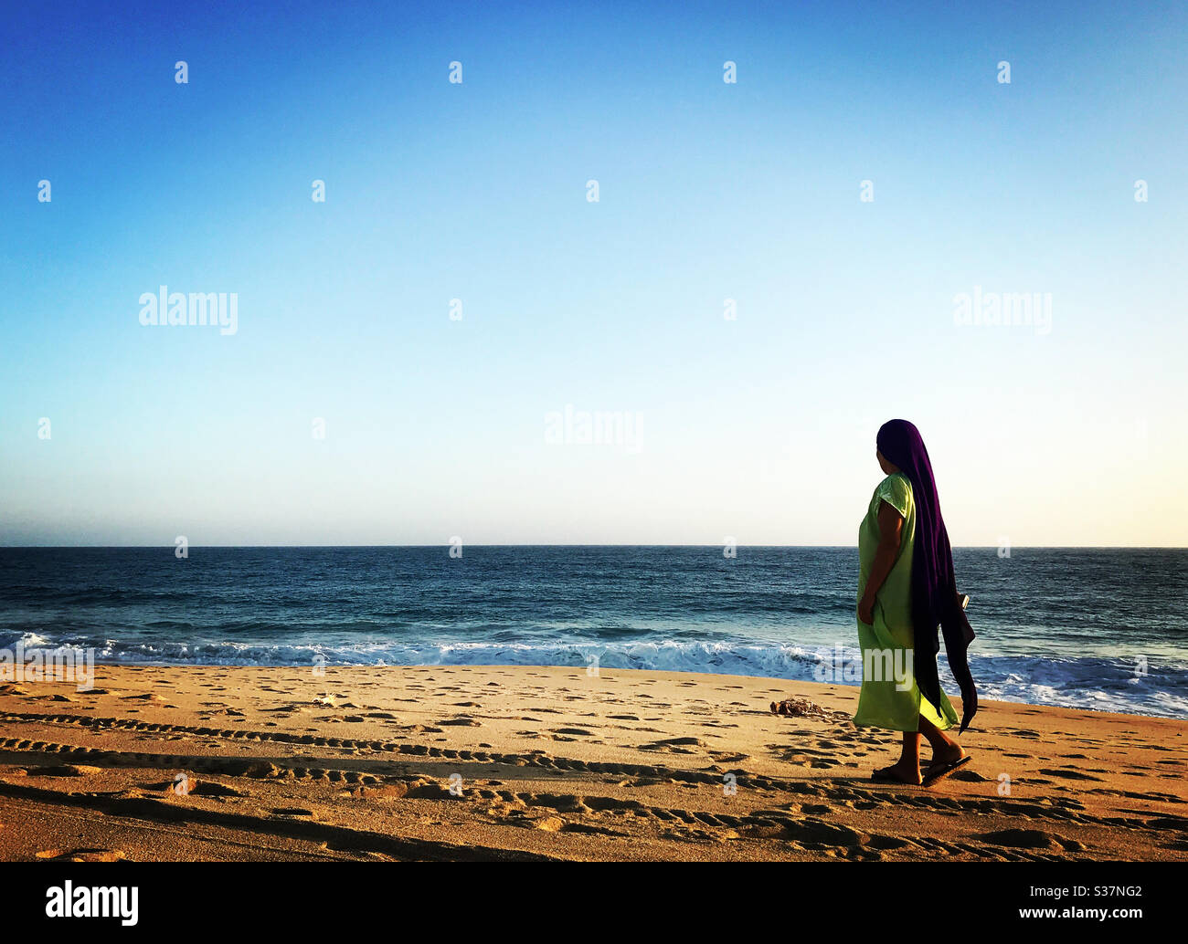 A Mexican woman walks in the beach in Todos Santos, Baja California, Mexico - Smartphone Captured Stock Image