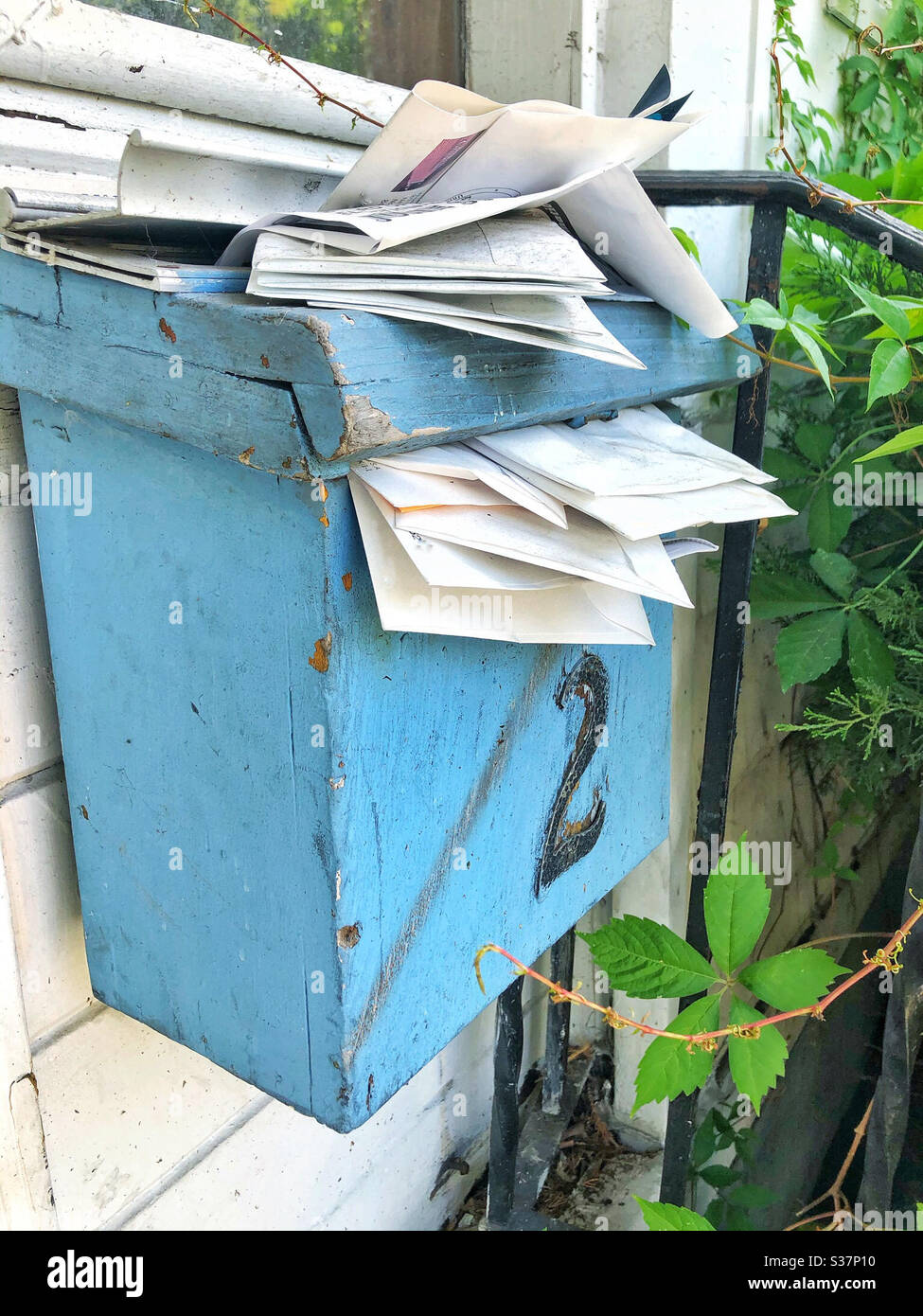 Mail overflowing mail box or post box at abandoned house - Smartphone Captured Stock Image