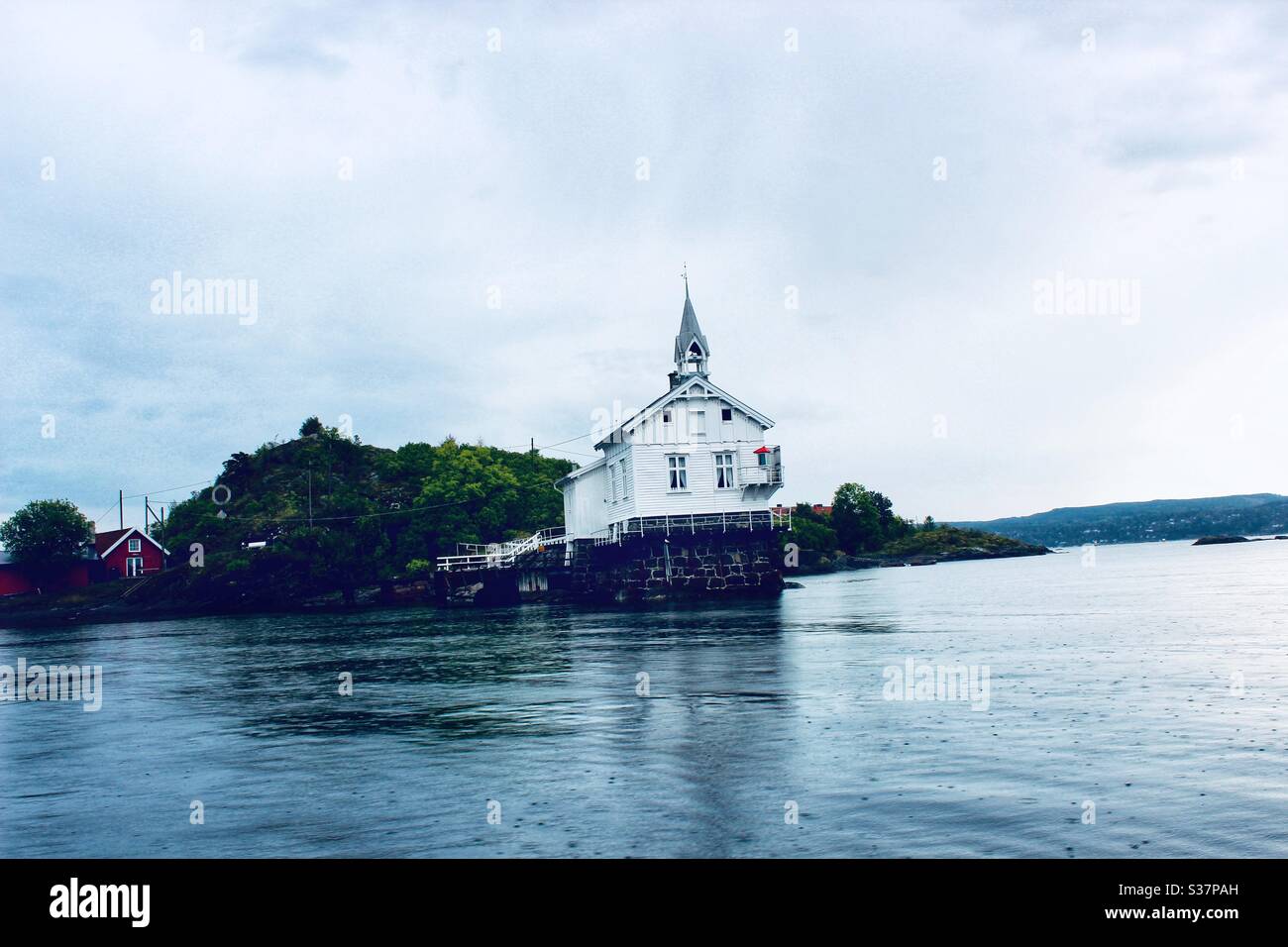 Rural church on landing in Norway surrounded by water Stock Photo
