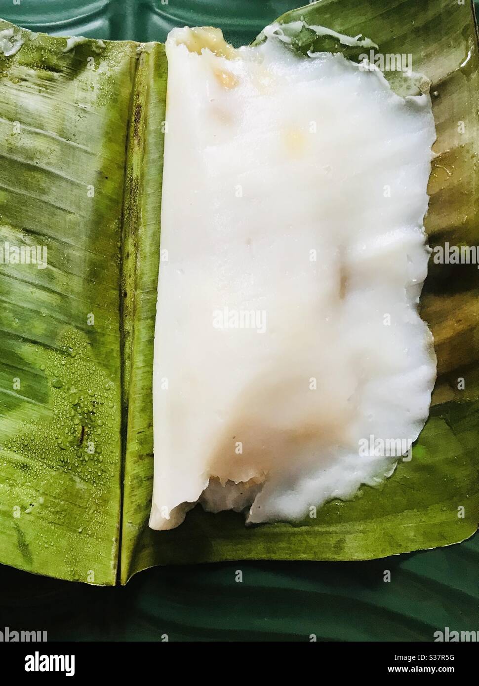 Home made Ela ada aka banana leaf pan cake - traditional kerala delicacy , dough made of rice flour with banana coconut jaggery fillings & steamed- evening snack or breakfast Stock Photo