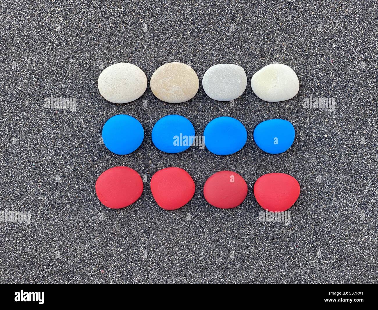 Russian flag composed with colored stones over black volcanic sand - Smartphone Captured Stock Image