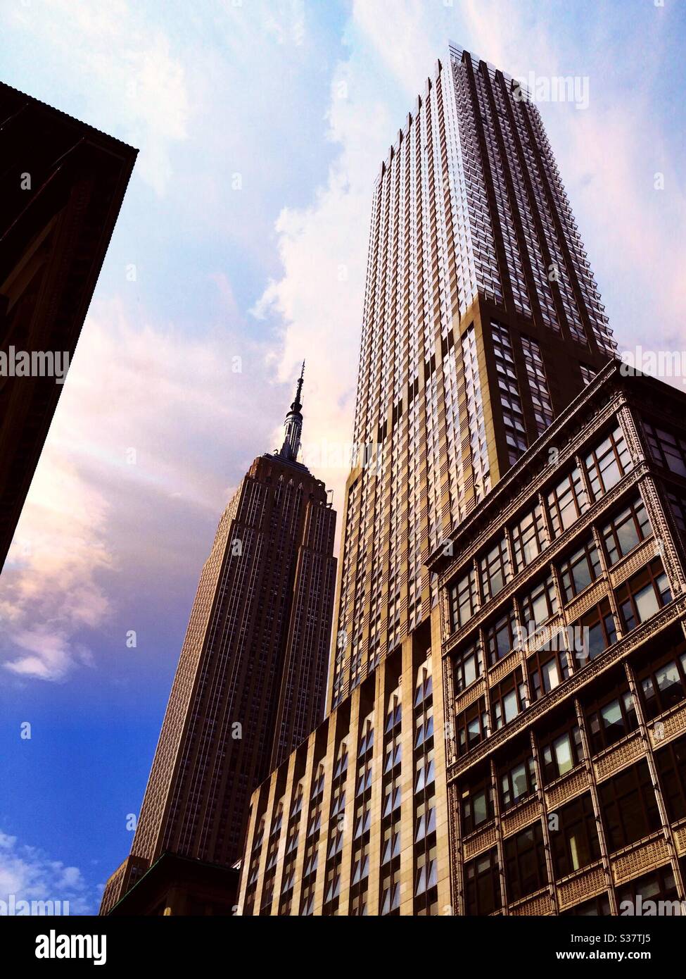 The Empire State building and the Langham hotel are located in Midtown Manhattan on fifth Avenue, NYC, USA - Smartphone Captured Stock Image