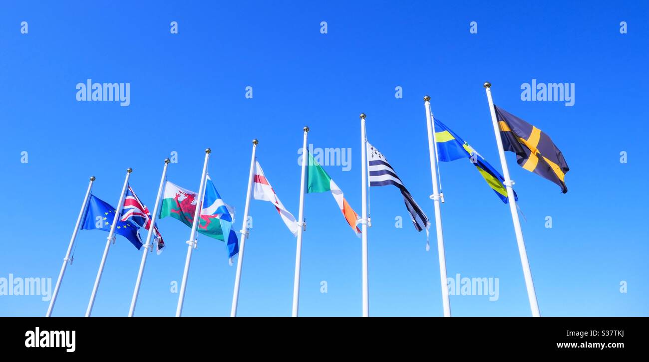 Flags blowing in the breeze under a clear, bright blue summer sky Stock Photo