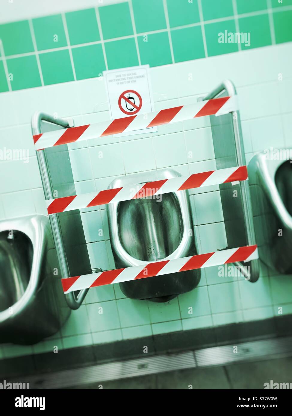 Pub toilets with middle gents urinal taped off due to Coronavirus social distancing rules as pubs re-open July 2020 UK Stock Photo
