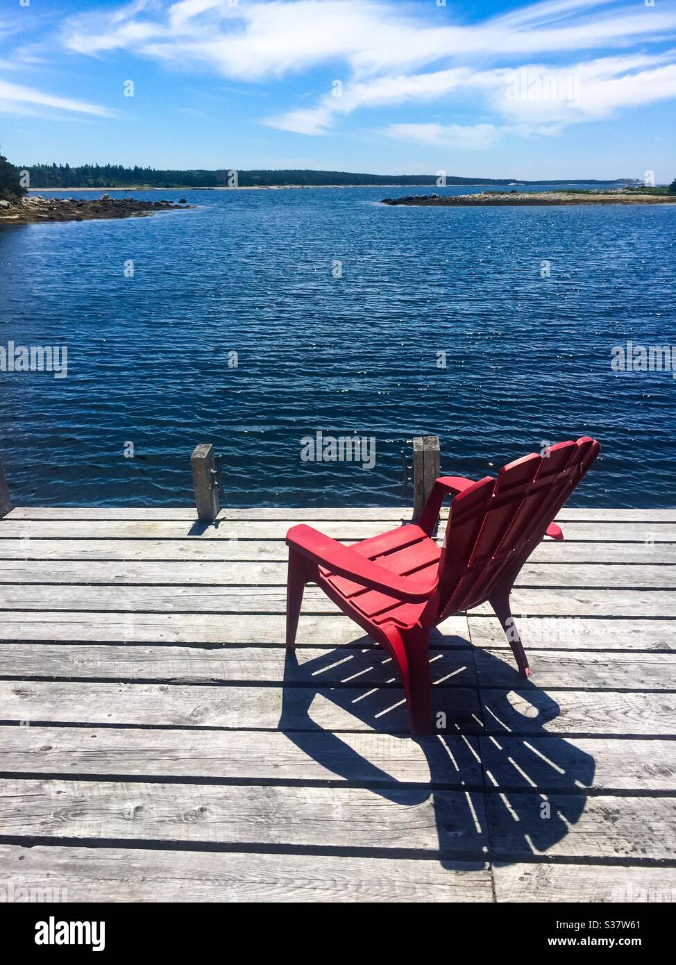 Red chair on the dock at the edge of the Atlantic - Smartphone Captured Stock Image