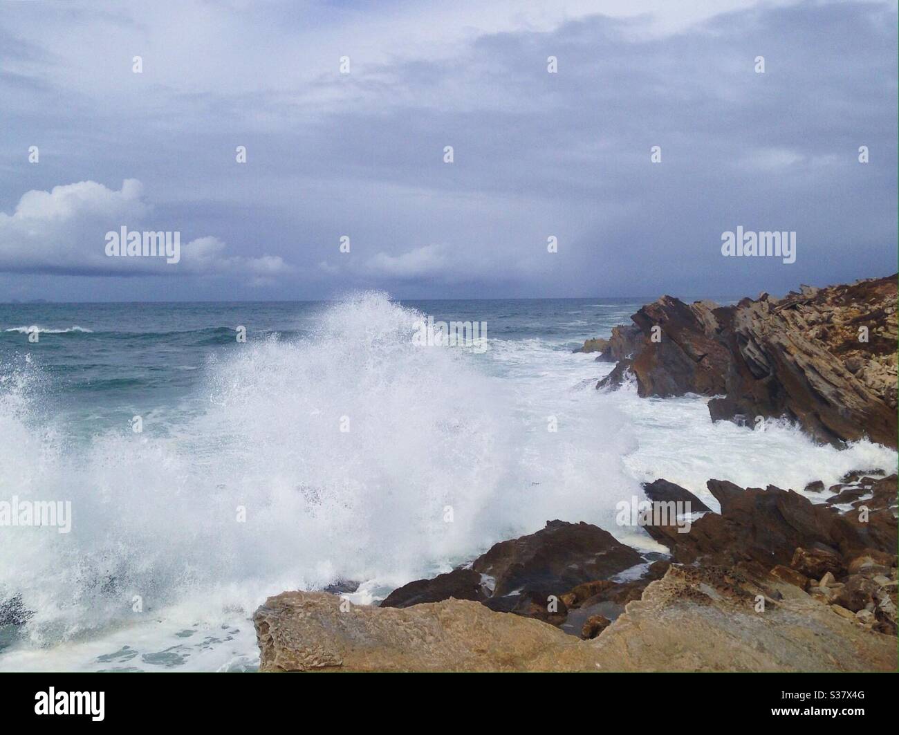 Summer view of ocean waves splashing on the rocks Stock Photo