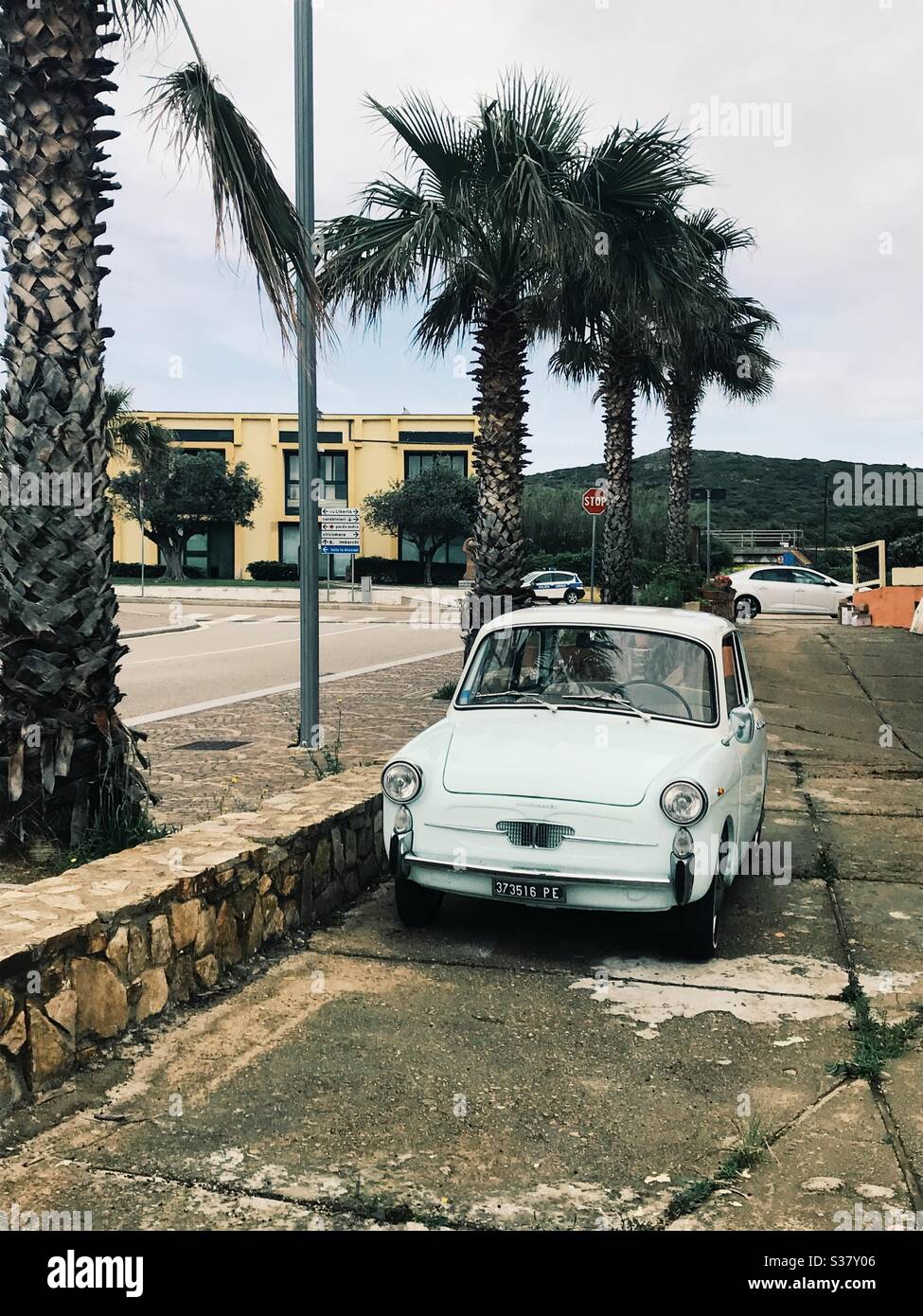 Retro Italian green car parked in a seaside town in Sardinia. Italy. Stock Photo