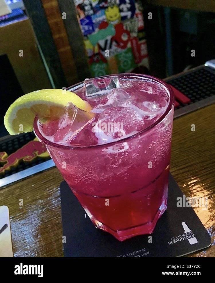 Pink lemonade prepared with grenadine, gin and lemon slice Stock Photo