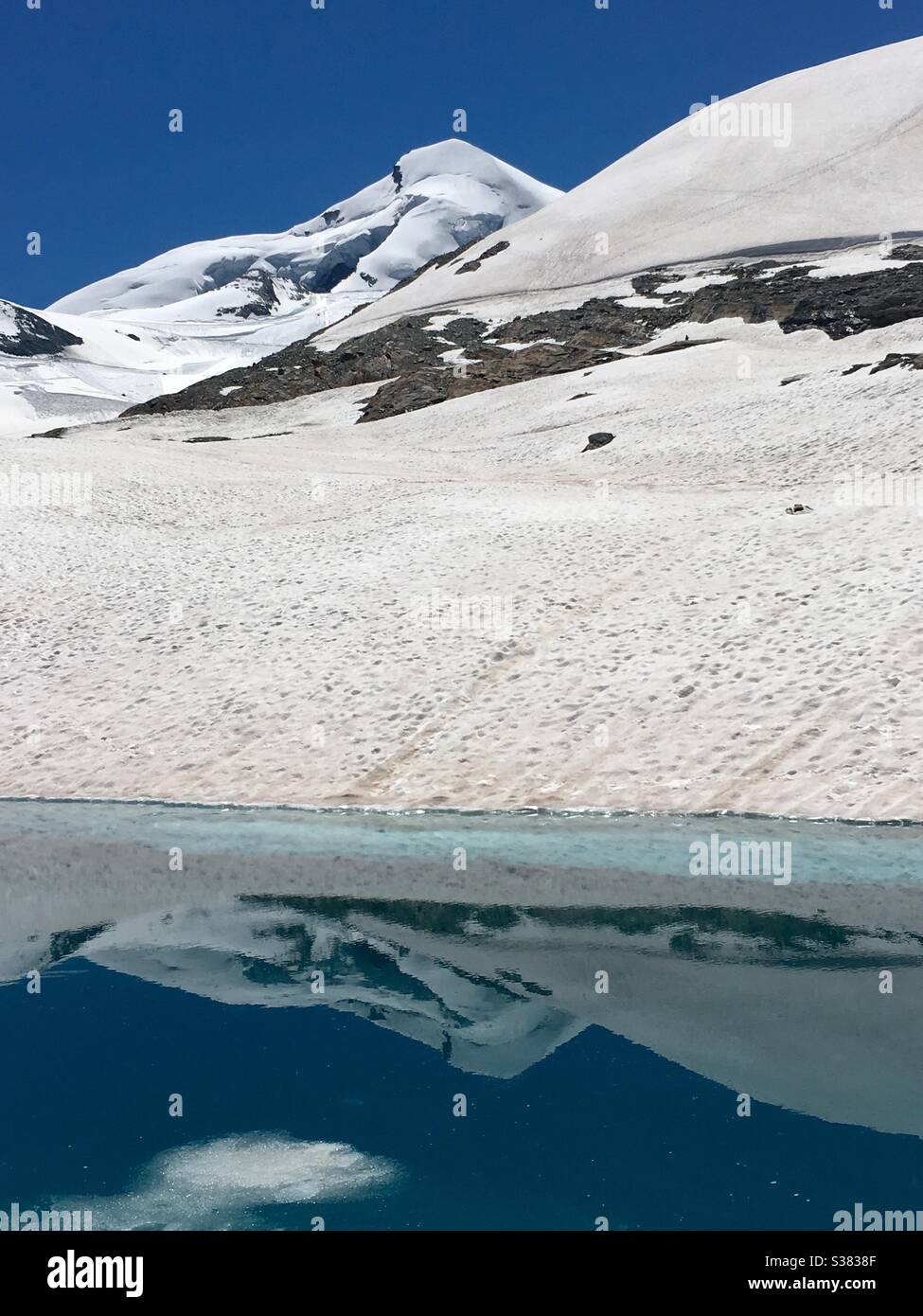 Allalinhorn reflection in lake in Feeglacier. Saas Fee, Valais, Switzerland. Stock Photo