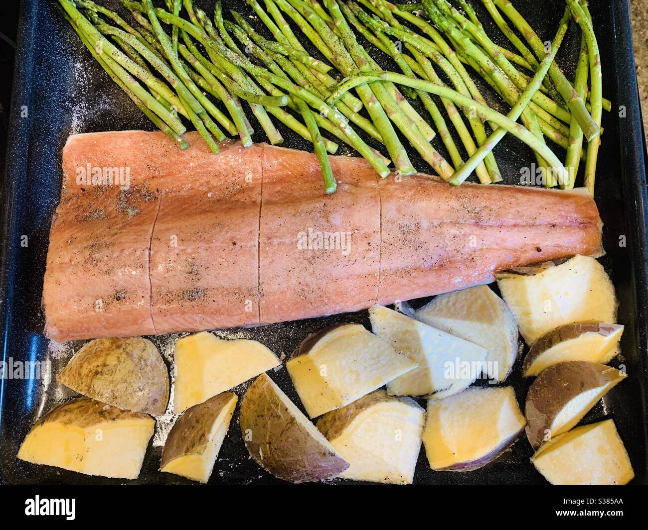 Healthy baked dinner: salmon, asparagus and rutabaga Stock Photo