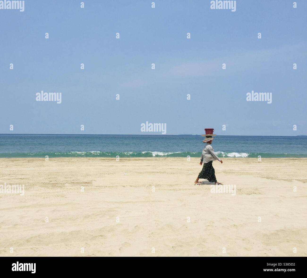 A lady walking on the beach Stock Photo