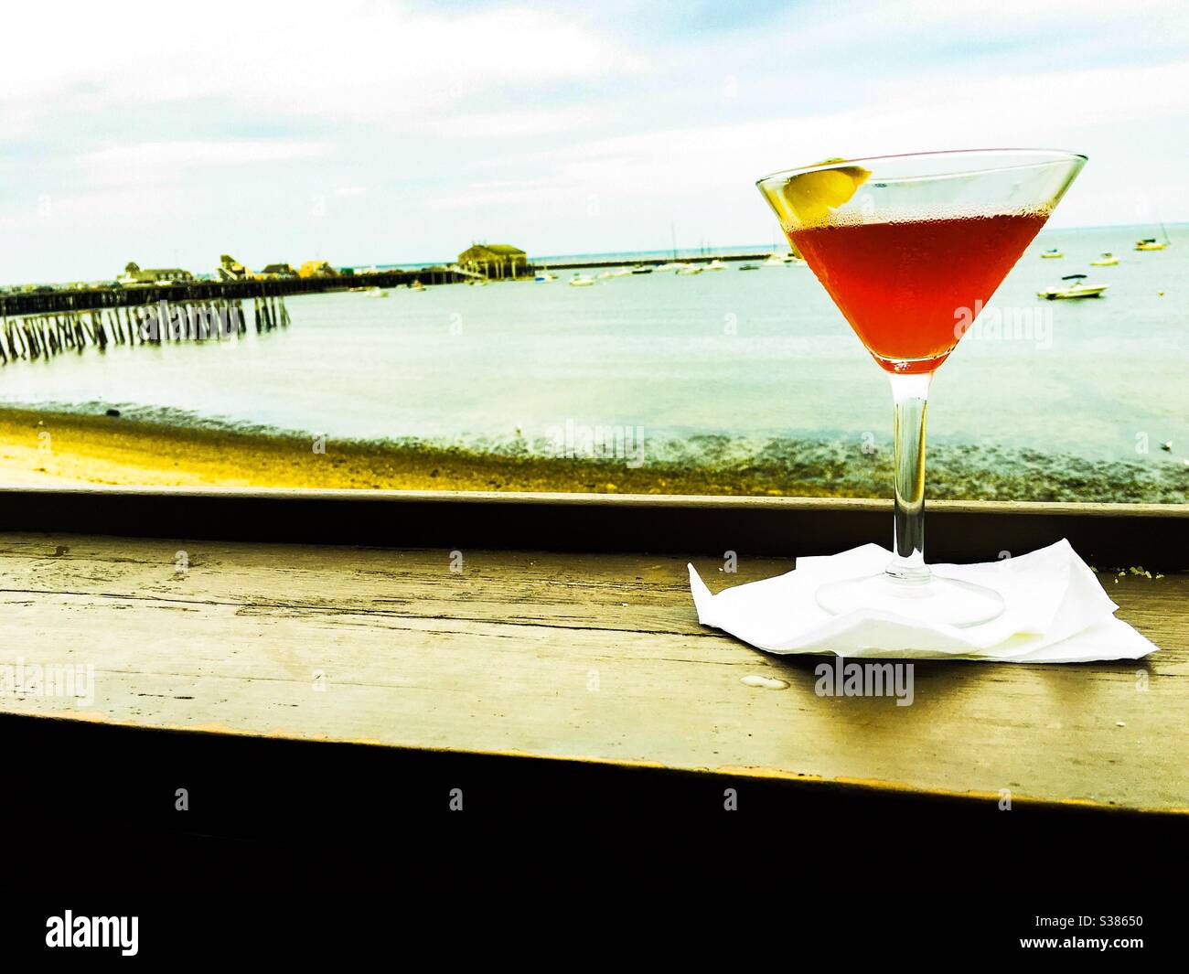 Drinks on the beach. A Cosmopolitan cocktail with the beach in the background a summer drink. Selective focus. Provincetown Cape Cod Massachusetts. - Smartphone Captured Stock Image