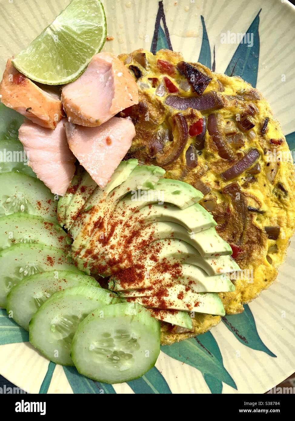 Plate of food containing cucumber avocado salmon omelette lime - Smartphone Captured Stock Image