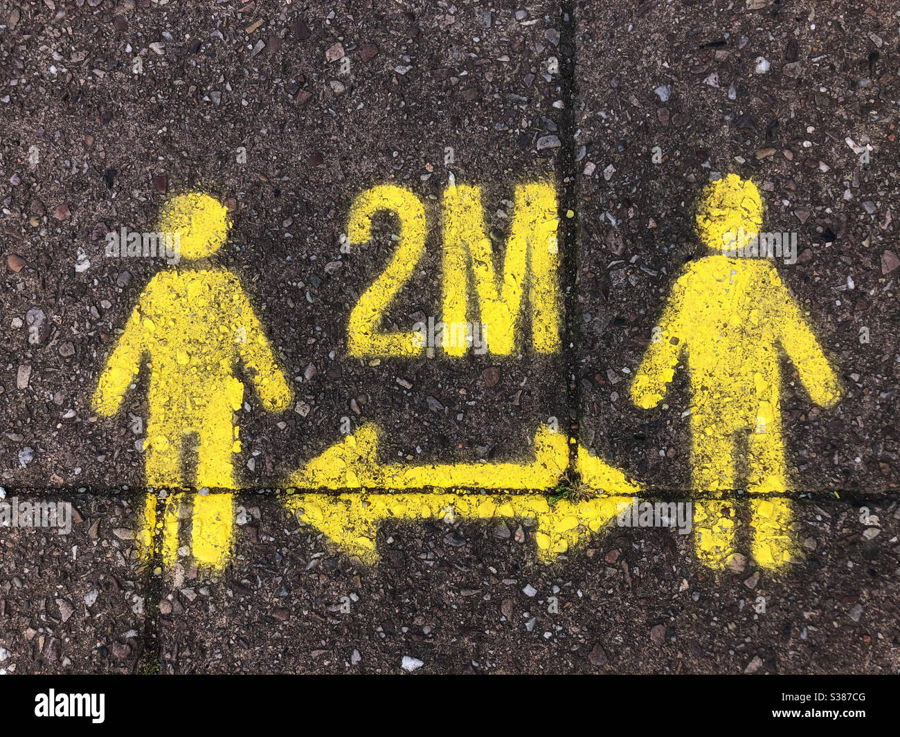 Social distancing sign on the pavement. Stock Photo