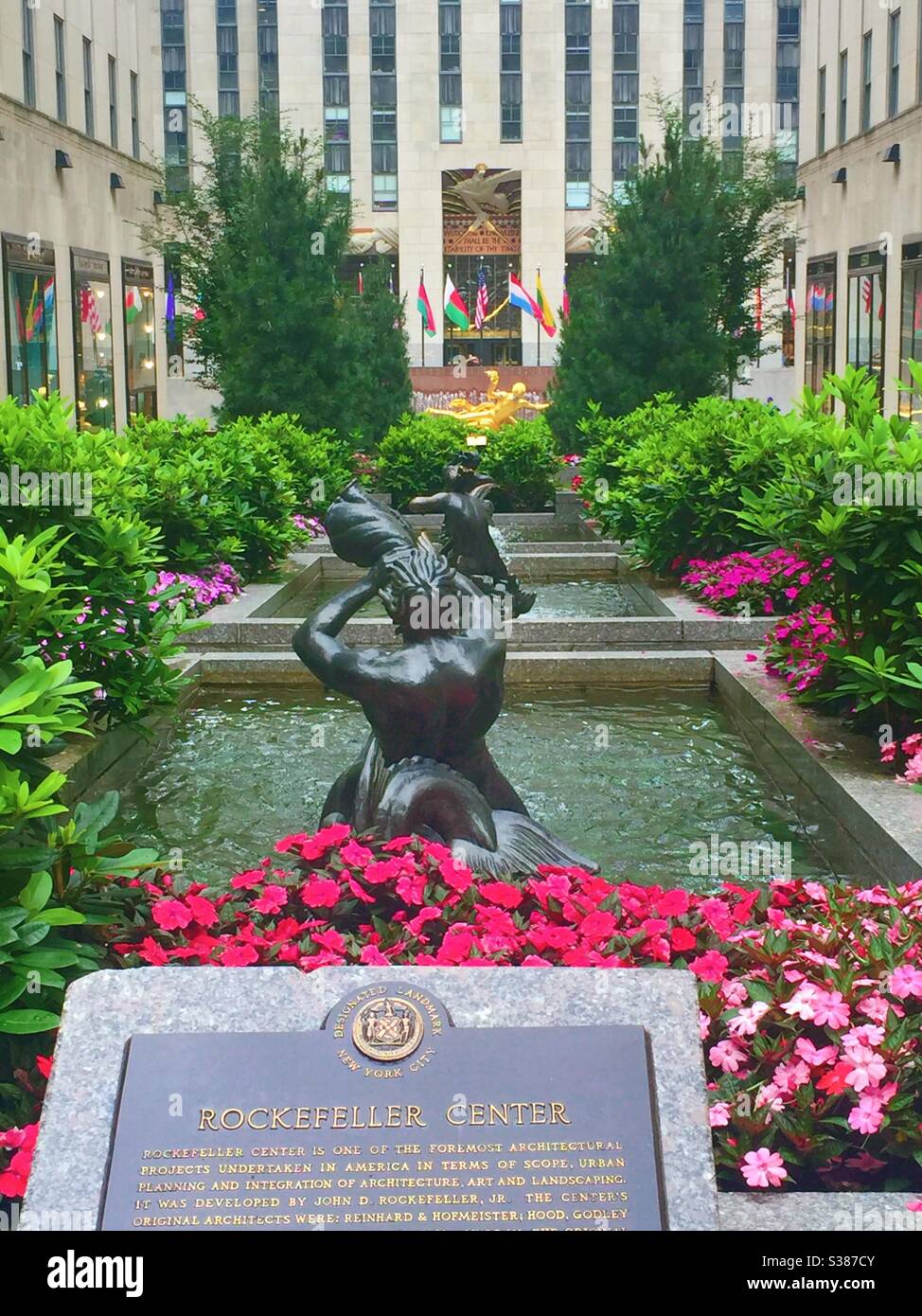 The channel Gardens in Rockefeller Center features fountains, flowers and Prometheus in the plaza in front of 30 rock sky scraper, NYC, USA - Smartphone Captured Stock Image