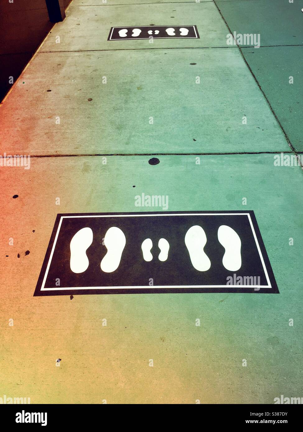 Sidewalk foot prints showing the proper social distancing necessary during the COVID-19 coronavirus to enter a building, NYC, 2020, USA - Smartphone Captured Stock Image